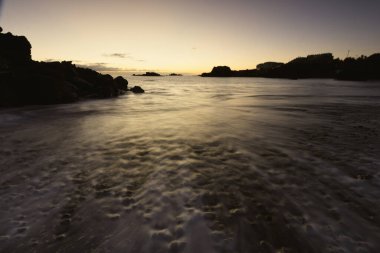 Los Cancajos sahilinde gün doğumunda uzun süre çekim, yumuşak su Atlantik kıyısında volkanik kayalara çarpıyor, La Palma, Kanarya Adaları, İspanya