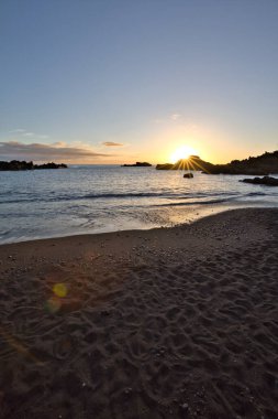 La Palma 'daki Los Cancajos' un kara kumsalında gün doğumu. Volkanik kayaların arkasında güneş patlaması var..