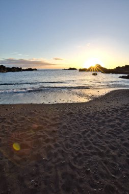 La Palma 'daki Los Cancajos' un kara kumsalında gün doğumu. Volkanik kayaların arkasında güneş patlaması var..