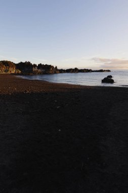 La Palma 'daki Los Cancajos' un kara kumsalında gün doğumu. Volkanik kayaların arkasında güneş patlaması var..