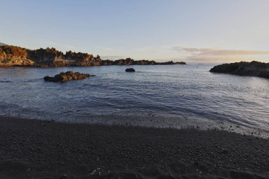 La Palma 'daki Los Cancajos' un kara kumsalında gün doğumu. Volkanik kayaların arkasında güneş patlaması var..