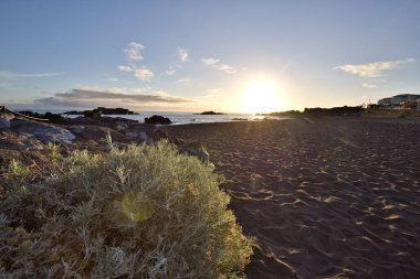 La Palma 'daki Los Cancajos' un kara kumsalında gün doğumu. Volkanik kayaların arkasında güneş patlaması var..