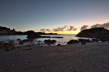 Los Cancajos sahilinde gün doğumunda uzun süre çekim, yumuşak su Atlantik kıyısında volkanik kayalara çarpıyor, La Palma, Kanarya Adaları, İspanya