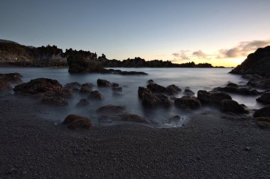 Los Cancajos sahilinde gün doğumunda uzun süre çekim, yumuşak su Atlantik kıyısında volkanik kayalara çarpıyor, La Palma, Kanarya Adaları, İspanya