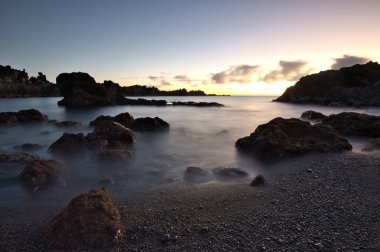 Los Cancajos sahilinde gün doğumunda uzun süre çekim, yumuşak su Atlantik kıyısında volkanik kayalara çarpıyor, La Palma, Kanarya Adaları, İspanya