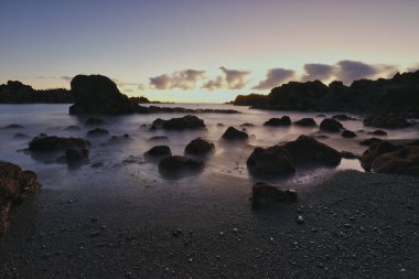 Los Cancajos sahilinde gün doğumunda uzun süre çekim, yumuşak su Atlantik kıyısında volkanik kayalara çarpıyor, La Palma, Kanarya Adaları, İspanya