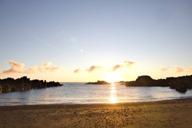 La Palma 'daki Los Cancajos' un kara kumsalında gün doğumu. Volkanik kayaların arkasında güneş patlaması var..