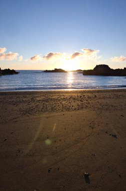 La Palma 'daki Los Cancajos' un kara kumsalında gün doğumu. Volkanik kayaların arkasında güneş patlaması var..