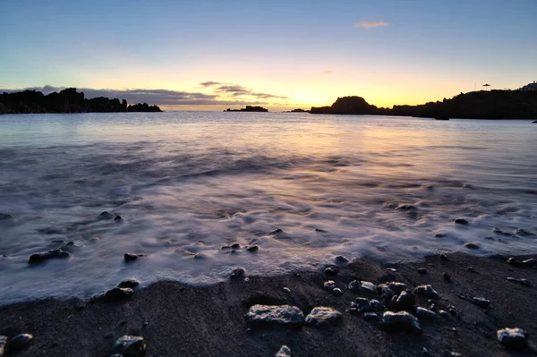 Los Cancajos sahilinde gün doğumunda uzun süre çekim, yumuşak su Atlantik kıyısında volkanik kayalara çarpıyor, La Palma, Kanarya Adaları, İspanya