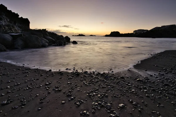 Los Cancajos sahilinde gün doğumunda uzun süre çekim, yumuşak su Atlantik kıyısında volkanik kayalara çarpıyor, La Palma, Kanarya Adaları, İspanya