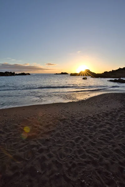 La Palma 'daki Los Cancajos' un kara kumsalında gün doğumu. Volkanik kayaların arkasında güneş patlaması var..