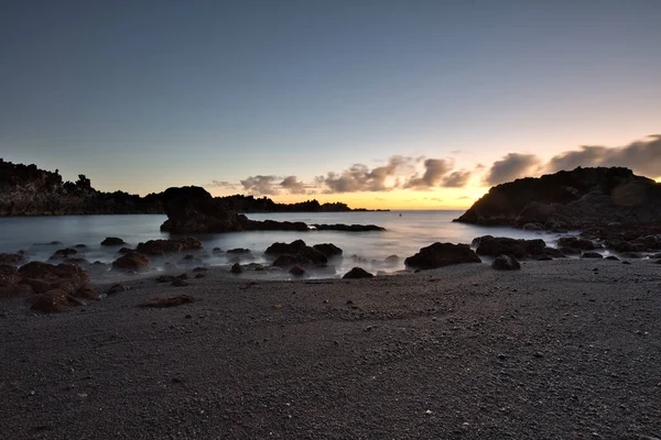 Los Cancajos sahilinde gün doğumunda uzun süre çekim, yumuşak su Atlantik kıyısında volkanik kayalara çarpıyor, La Palma, Kanarya Adaları, İspanya