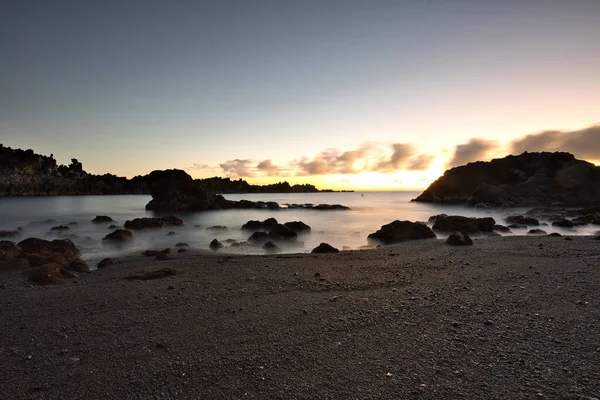 Los Cancajos sahilinde gün doğumunda uzun süre çekim, yumuşak su Atlantik kıyısında volkanik kayalara çarpıyor, La Palma, Kanarya Adaları, İspanya