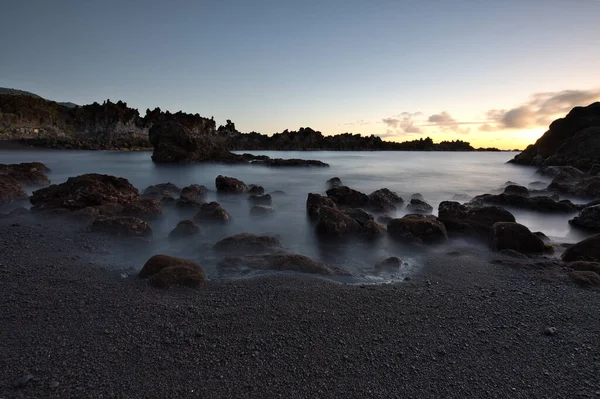 Los Cancajos sahilinde gün doğumunda uzun süre çekim, yumuşak su Atlantik kıyısında volkanik kayalara çarpıyor, La Palma, Kanarya Adaları, İspanya
