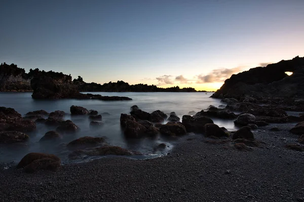 Los Cancajos sahilinde gün doğumunda uzun süre çekim, yumuşak su Atlantik kıyısında volkanik kayalara çarpıyor, La Palma, Kanarya Adaları, İspanya