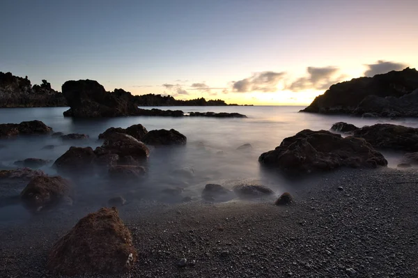 Los Cancajos sahilinde gün doğumunda uzun süre çekim, yumuşak su Atlantik kıyısında volkanik kayalara çarpıyor, La Palma, Kanarya Adaları, İspanya