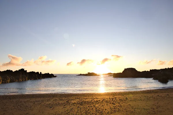 La Palma 'daki Los Cancajos' un kara kumsalında gün doğumu. Volkanik kayaların arkasında güneş patlaması var..