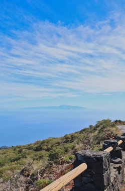 Roque de los Muchachos, La Palma 'da ahşap korkuluklu dolambaçlı dağ yolu. Mavi Atlantik Okyanusu 'na doğru volkanik kayaların üzerinden manzara. Yüksek irtifa yolculuk yolculuğu