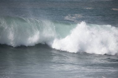Büyük bir Atlantik dalgası Tazacorte sahiline çarpıyor. Beyaz köpük ve spreyle kırılan turkuaz suyun yakın çekimi denizin evcilleştirilmemiş gücünü gösteriyor. La Palma, Kanarya Adaları, İspanya