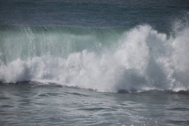 Büyük bir Atlantik dalgası Tazacorte sahiline çarpıyor. Beyaz köpük ve spreyle kırılan turkuaz suyun yakın çekimi denizin evcilleştirilmemiş gücünü gösteriyor. La Palma, Kanarya Adaları, İspanya
