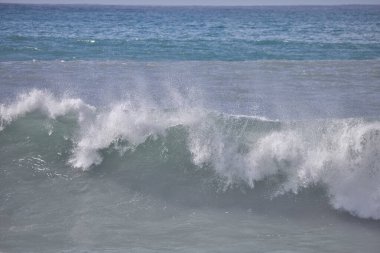 Büyük bir Atlantik dalgası Tazacorte sahiline çarpıyor. Beyaz köpük ve spreyle kırılan turkuaz suyun yakın çekimi denizin evcilleştirilmemiş gücünü gösteriyor. La Palma, Kanarya Adaları, İspanya