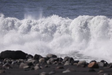 Şiddetli Atlantik dalgaları taş merdivenlere ve Tazacorte limanının dalgalanan sularına çarpıyor. La Palma kıyısındaki karanlık volkanik kayaların üzerine yüksek su püskürtüsü ve köpük..