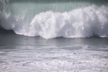 Büyük bir Atlantik dalgası Tazacorte sahiline çarpıyor. Beyaz köpük ve spreyle kırılan turkuaz suyun yakın çekimi denizin evcilleştirilmemiş gücünü gösteriyor. La Palma, Kanarya Adaları, İspanya