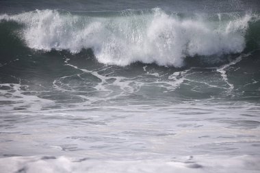 Büyük bir Atlantik dalgası Tazacorte sahiline çarpıyor. Beyaz köpük ve spreyle kırılan turkuaz suyun yakın çekimi denizin evcilleştirilmemiş gücünü gösteriyor. La Palma, Kanarya Adaları, İspanya