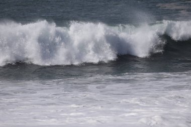 Büyük bir Atlantik dalgası Tazacorte sahiline çarpıyor. Beyaz köpük ve spreyle kırılan turkuaz suyun yakın çekimi denizin evcilleştirilmemiş gücünü gösteriyor. La Palma, Kanarya Adaları, İspanya