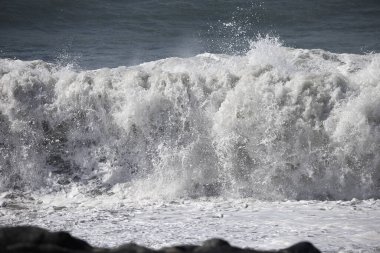 Büyük bir Atlantik dalgası Tazacorte sahiline çarpıyor. Beyaz köpük ve spreyle kırılan turkuaz suyun yakın çekimi denizin evcilleştirilmemiş gücünü gösteriyor. La Palma, Kanarya Adaları, İspanya