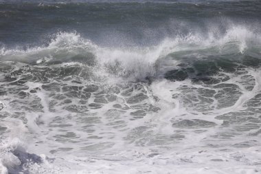 Büyük bir Atlantik dalgası Tazacorte sahiline çarpıyor. Beyaz köpük ve spreyle kırılan turkuaz suyun yakın çekimi denizin evcilleştirilmemiş gücünü gösteriyor. La Palma, Kanarya Adaları, İspanya