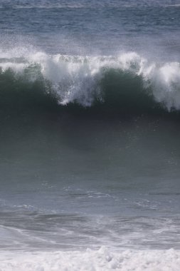 Büyük bir Atlantik dalgası Tazacorte sahiline çarpıyor. Beyaz köpük ve spreyle kırılan turkuaz suyun yakın çekimi denizin evcilleştirilmemiş gücünü gösteriyor. La Palma, Kanarya Adaları, İspanya