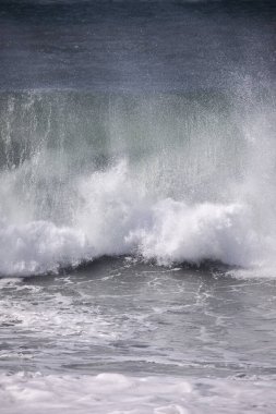 Büyük bir Atlantik dalgası Tazacorte sahiline çarpıyor. Beyaz köpük ve spreyle kırılan turkuaz suyun yakın çekimi denizin evcilleştirilmemiş gücünü gösteriyor. La Palma, Kanarya Adaları, İspanya