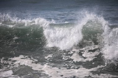 Büyük bir Atlantik dalgası Tazacorte sahiline çarpıyor. Beyaz köpük ve spreyle kırılan turkuaz suyun yakın çekimi denizin evcilleştirilmemiş gücünü gösteriyor. La Palma, Kanarya Adaları, İspanya