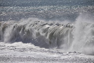 Büyük bir Atlantik dalgası Tazacorte sahiline çarpıyor. Beyaz köpük ve spreyle kırılan turkuaz suyun yakın çekimi denizin evcilleştirilmemiş gücünü gösteriyor. La Palma, Kanarya Adaları, İspanya