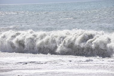Büyük bir Atlantik dalgası Tazacorte sahiline çarpıyor. Beyaz köpük ve spreyle kırılan turkuaz suyun yakın çekimi denizin evcilleştirilmemiş gücünü gösteriyor. La Palma, Kanarya Adaları, İspanya
