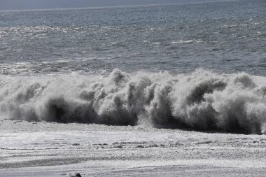 Büyük bir Atlantik dalgası Tazacorte sahiline çarpıyor. Beyaz köpük ve spreyle kırılan turkuaz suyun yakın çekimi denizin evcilleştirilmemiş gücünü gösteriyor. La Palma, Kanarya Adaları, İspanya