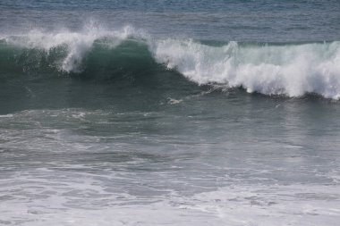 Büyük bir Atlantik dalgası Tazacorte sahiline çarpıyor. Beyaz köpük ve spreyle kırılan turkuaz suyun yakın çekimi denizin evcilleştirilmemiş gücünü gösteriyor. La Palma, Kanarya Adaları, İspanya