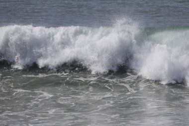 Büyük bir Atlantik dalgası Tazacorte sahiline çarpıyor. Beyaz köpük ve spreyle kırılan turkuaz suyun yakın çekimi denizin evcilleştirilmemiş gücünü gösteriyor. La Palma, Kanarya Adaları, İspanya