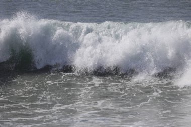 Büyük bir Atlantik dalgası Tazacorte sahiline çarpıyor. Beyaz köpük ve spreyle kırılan turkuaz suyun yakın çekimi denizin evcilleştirilmemiş gücünü gösteriyor. La Palma, Kanarya Adaları, İspanya