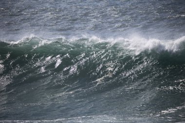 Büyük bir Atlantik dalgası Tazacorte sahiline çarpıyor. Beyaz köpük ve spreyle kırılan turkuaz suyun yakın çekimi denizin evcilleştirilmemiş gücünü gösteriyor. La Palma, Kanarya Adaları, İspanya