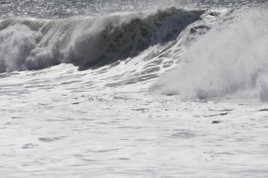 Büyük bir Atlantik dalgası Tazacorte sahiline çarpıyor. Beyaz köpük ve spreyle kırılan turkuaz suyun yakın çekimi denizin evcilleştirilmemiş gücünü gösteriyor. La Palma, Kanarya Adaları, İspanya