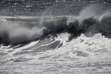 Büyük bir Atlantik dalgası Tazacorte sahiline çarpıyor. Beyaz köpük ve spreyle kırılan turkuaz suyun yakın çekimi denizin evcilleştirilmemiş gücünü gösteriyor. La Palma, Kanarya Adaları, İspanya
