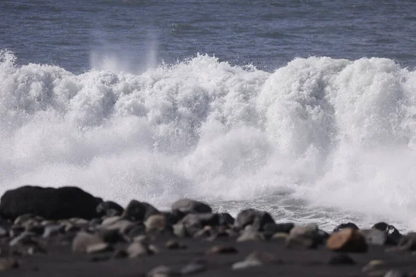 Şiddetli Atlantik dalgaları taş merdivenlere ve Tazacorte limanının dalgalanan sularına çarpıyor. La Palma kıyısındaki karanlık volkanik kayaların üzerine yüksek su püskürtüsü ve köpük..