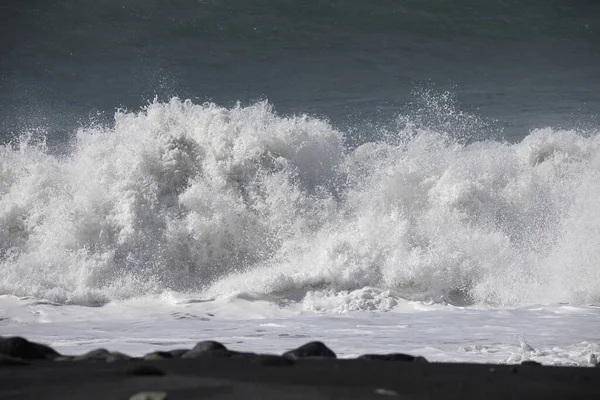 Büyük bir Atlantik dalgası Tazacorte sahiline çarpıyor. Beyaz köpük ve spreyle kırılan turkuaz suyun yakın çekimi denizin evcilleştirilmemiş gücünü gösteriyor. La Palma, Kanarya Adaları, İspanya