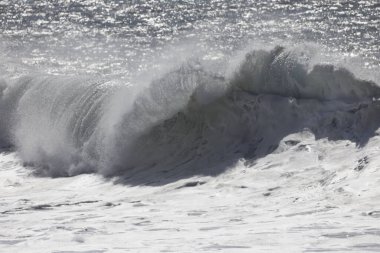 Büyük bir Atlantik dalgası Tazacorte sahiline çarpıyor. Beyaz köpük ve spreyle kırılan turkuaz suyun yakın çekimi denizin evcilleştirilmemiş gücünü gösteriyor. La Palma, Kanarya Adaları, İspanya