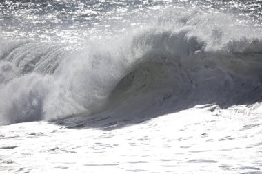 Büyük bir Atlantik dalgası Tazacorte sahiline çarpıyor. Beyaz köpük ve spreyle kırılan turkuaz suyun yakın çekimi denizin evcilleştirilmemiş gücünü gösteriyor. La Palma, Kanarya Adaları, İspanya