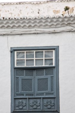 Geleneksel ahşap bir balkonun simetrik fotoğrafı Santa Cruz de La Palma, Kanarya Adaları 'ndaki eski ev önlerinde.
