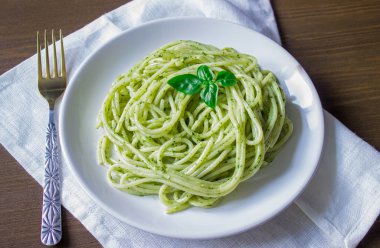 pesto sos ve fesleğen ile makarna yapraklar beyaz tabak, ahşap arka plan, üstten görünüm