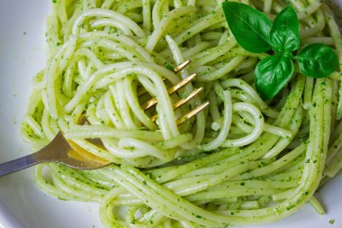 pesto sos ve fesleğen ile makarna yapraklar beyaz tabak, ahşap arka plan, üstten görünüm